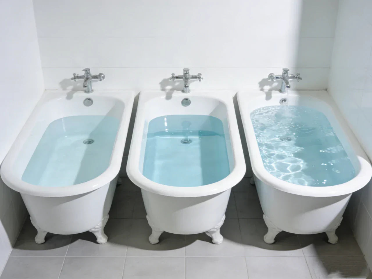 Three clawfoot bathtubs with varying water levels, showing how different fills affect total litre capacity.